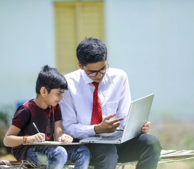 Two indian brother using laptop , Online education concept
